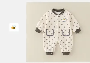 Detail of infant romper with cute giraffe patch and brown polka dot patterns on soft fabric