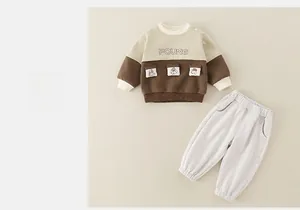 Macro detail of cotton baby boy set with FOUNG lettering and cartoon pocket embroidery