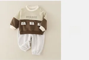 Detail view of cotton infant set with shoulder buttons and cartoon pocket embroidery