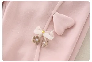 Close-up of pink knit cotton fabric with heart patch and floral embroidery for baby girls