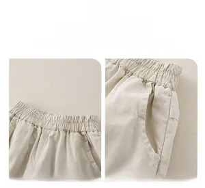 Close-up of elastic waistband and functional side pockets on beige cotton baby trousers
