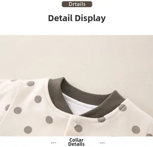 Detail of baby onesie ribbed brown collar with white snap button and brown polka dots