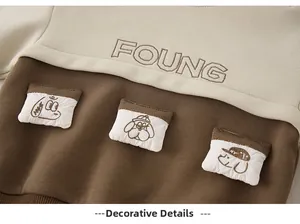 Close-up of cotton baby sweatshirt featuring FOUNG embroidery and cute puppy pockets