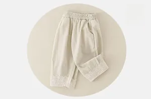 Close-up of baby cotton pants featuring elastic waist and delicate white lace hem details