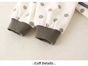 Close-up of elastic grey ribbed cuffs on polka dot pattern cotton baby romper fabric