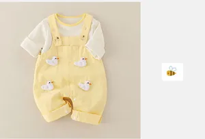 Detail of infant cotton set featuring wood buttons and 3D duck appliques on overalls