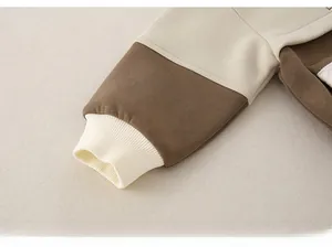 Detail of baby sweatshirt ribbed cuffs featuring beige and brown color-blocking design