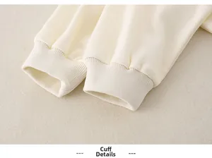 Close-up of baby clothing ribbed cuffs showing soft cream knit fabric texture and quality