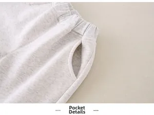 Detailed macro view of the pocket construction and elastic waist on grey cotton infant pants