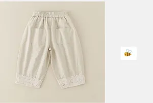 Detail of baby girl casual pants featuring elastic waist and lace embroidery on cuffs