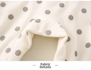 Detailed view of soft cream knit fabric with grey polka dots for baby rompers