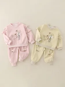 Baby girl spring floral sweatshirt and pants set with ruffle details on clean background