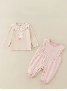 Detail of infant two-piece set featuring a cute bunny patch and delicate lace collar
