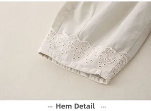Close-up of cotton baby pants with intricate floral embroidery lace at the leg opening