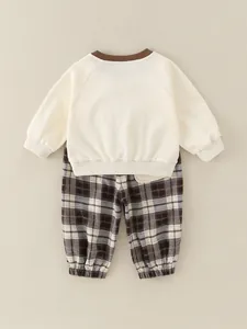 Minimalist baby two-piece set featuring a beige ribbed sweatshirt and brown checkered pants
