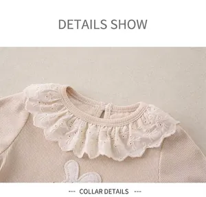 Macro detail of rib-knit baby shirt with white lace collar and bunny embroidery