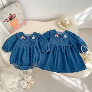 Close-up of baby denim dress with Peter Pan collar and cute cartoon animal embroidery