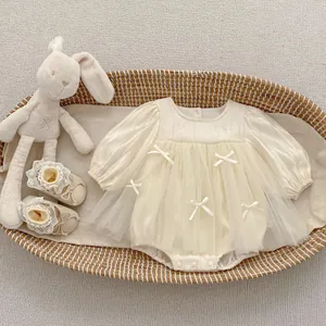 Detail view of cream toddler romper with mesh tutu, bows and matching lace shoes