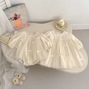 Detailed view of cream mesh dress for baby girls featuring elegant bow and puff sleeves