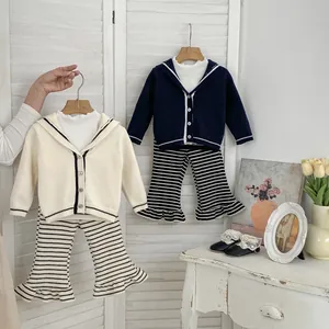 Detail of girls' knitted cardigan with sailor collar and striped flared trousers set