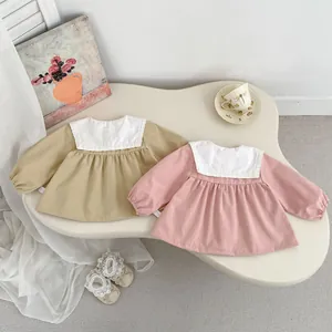 Detailed flat lay of long sleeve toddler dresses with lace collars in khaki and pink
