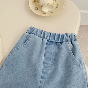 Detailed view of girls light blue denim jeans with elastic pleated waist and pockets