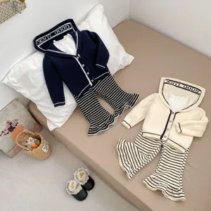 Detail of girls knit hoodie with Good Luck text and striped flare pants set