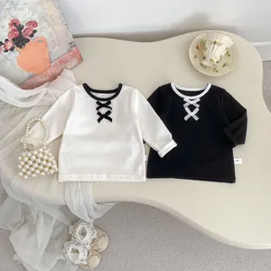 Dettaglio delle magliette in cotone per bambine con fiocchi e girocollo a contrasto