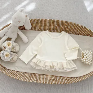 Infant girl beige long-sleeved T-shirt with lace ruffles in a cozy woven basket