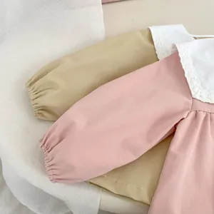 Detailed view of the soft pink and khaki cotton blouses with lace collar and elastic cuffs
