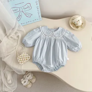 Detail of light blue baby romper featuring delicate lace Peter Pan collar and bow embroidery