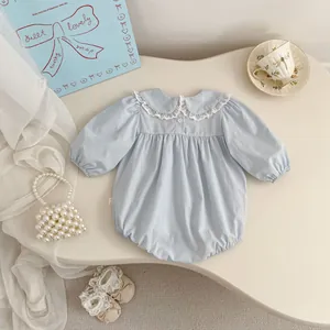 Detail of light blue baby romper featuring a delicate white lace Peter Pan collar