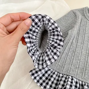 Detail van grijs gebreid vest met elastische ruches met ruitpatroon op de mouwmanchetten