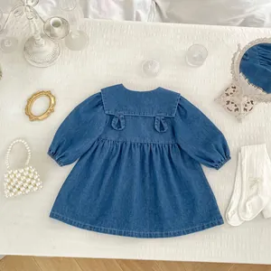 Detail of girls denim dress with large sailor collar and cute cartoon embroidery