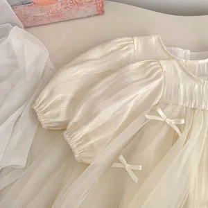 Close-up of elegant puff sleeves and layered mesh skirt with delicate bow detail