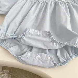 Detail of snap button closure and elastic leg openings on baby blue cotton romper