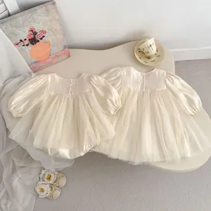 Detail of baby girl cream mesh princess dress with puffed sleeves and delicate tulle skirt