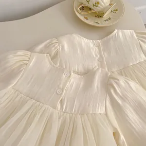 Detail of baby girl cream mesh dress with puff sleeves and vintage button back closure