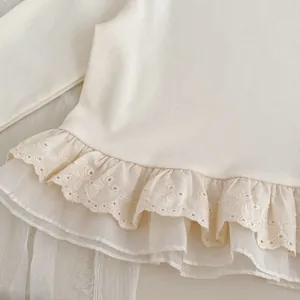 White girls' long sleeve cotton top featuring delicate embroidered lace hem and ruffles