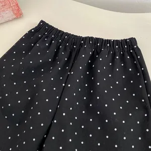 Dettaglio dei pantaloni a gamba larga a pois per bambine con elastico in vita e twill