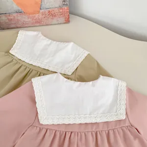 Close-up of girls cotton dress featuring white lace Peter Pan collar in pink and khaki colors