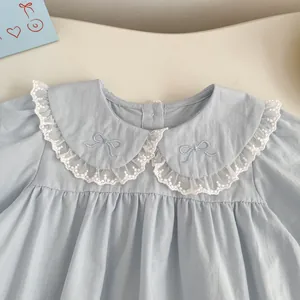 Detailed view of baby girl blue romper with lace Peter Pan collar and bow embroidery