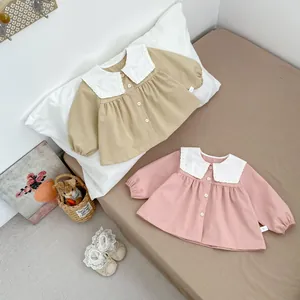 Detail of baby girl cotton dress showing lace Peter Pan collar and wooden buttons