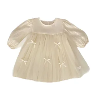 Cream long sleeve girls dress with satin bodice, tutu tulle skirt and white bows