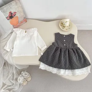 Detalle de conjunto para bebé niña con top de encaje y vestido de lunares