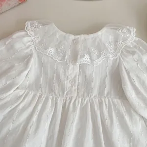 Detailed view of white baby dress featuring lace Peter Pan collar with floral embroidery