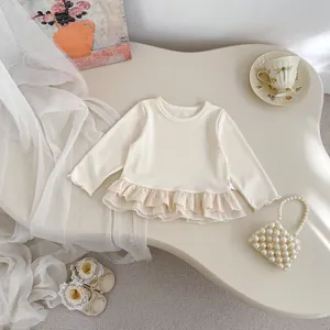 Detailed view of cream baby top with double-layer lace hem and matching accessories