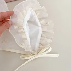 Nahaufnahme der Baby-Sonnenmütze mit Spitzenrüschen und floralen Stickerei-Details