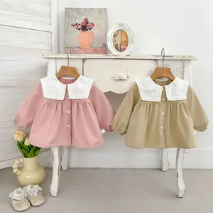 Close-up of cotton baby cardigans with vintage lace collars in pink and khaki colors