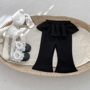 Dettaglio dei pantaloni svasati neri per bambine con ruffles in vita nella culla